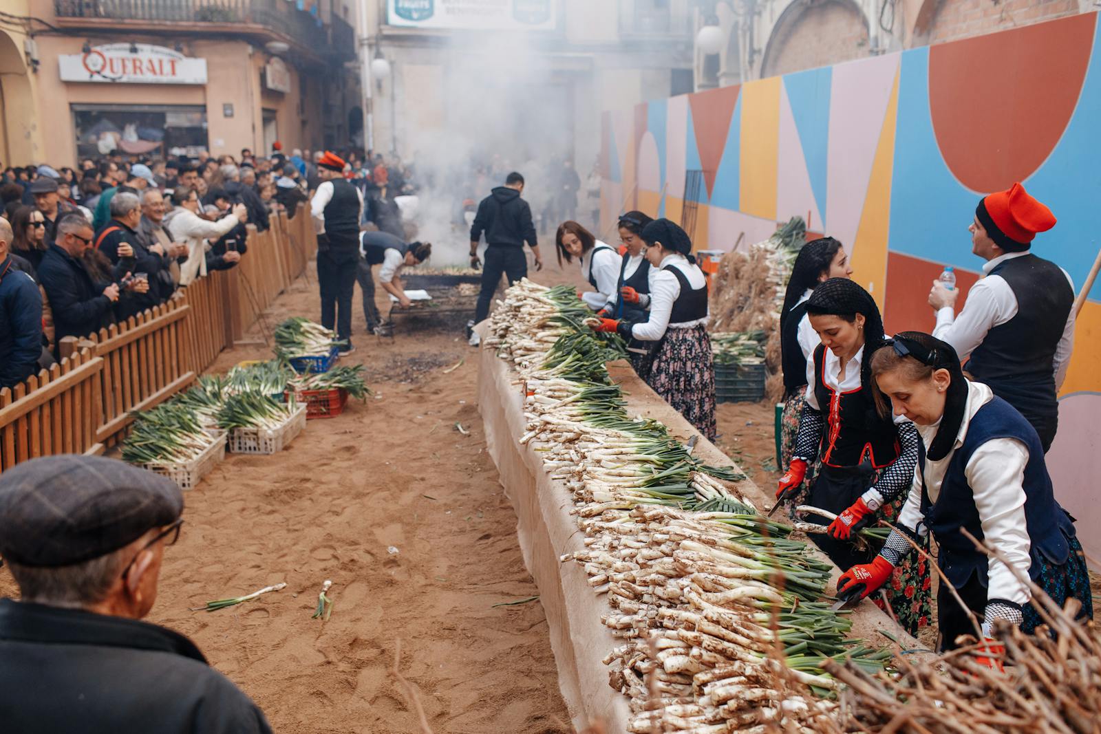 Home Gent amb roba tradicional al voltant d'una taula a una calcotada